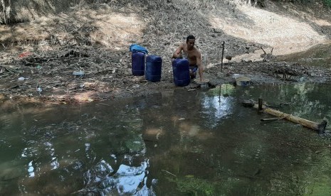 Warga Desa Ridogalih sedang mengambil air di Kali Cihoe yang mulai mengering pada Jumat (28/6). Desa Ridogalih merupakan satu dari tiga desa di Kecamatan Cibarusah, Kabupaten Bekasi, yang dilanda kekeringan sejak dua bulan terakhir. 