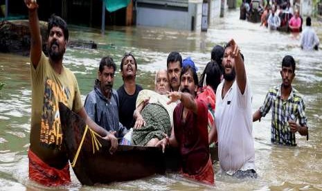 Warga di India menggunakan perahu karet untuk menyelamatkan seorang kakek yang terjebak banjir di Kochi, Negara Bagian Kerala.