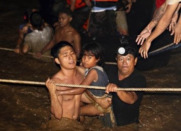  Warga diselamat oleh petugas menyusul banjir badang yang menerjang Kota Cagayan de Oro, Filipina, Sabtu (17/12). 