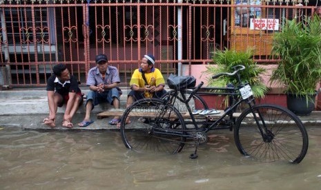   Warga duduk di pinggir jalan saat banjir melanda perumahan Ciledug indah 1, Ciledug, Tangerang, Banten, Kamis (16/1).    (Republika/Yasin Habibi)