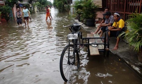   Warga duduk di pinggir jalan saat banjir melanda perumahan Ciledug indah 1, Ciledug, Tangerang, Banten, Kamis (16/1).    (Republika/Yasin Habibi)