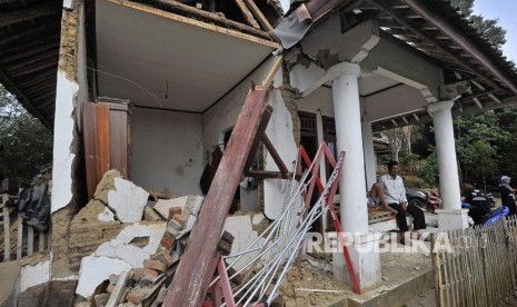 Warga duduk di rumahnya yang rusak akibat diguncang gempa di Kampung Karoya, Mandalawangi, Pandeglang, Banten, Sabtu (3/8/2019).