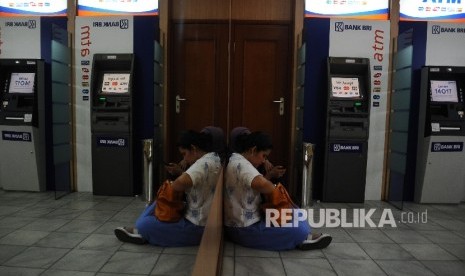 Warga duduk pada ruangan Anjungan Tunai Mandiri di ATM Centre, Jakarta, Rabu (20/4). (Republika/ Tahta Aidilla)