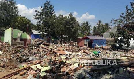 Warga Dusun Dangiang Timur, Desa Kayangan, Kabupaten Lombok Utara (KLU), Zikri (30), membersihkan puing dan kembali membangun rumahnya secara mandiri pada Kamis (30/8).