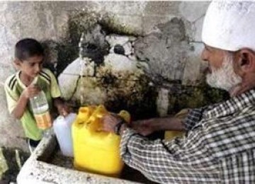 Warga Gaza mengambil air minum di sebuah pompa air.