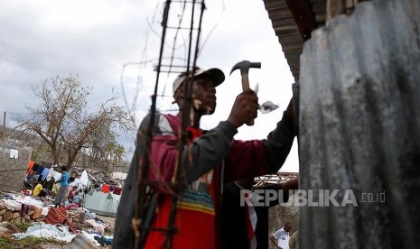 Warga Haiti memperbaiki rumahnya yang hancur.