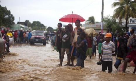 Warga Haiti menyaksikan jalan yang banjir akibat Topan Matthew di Leogane, Haiti, Rabu, 5 Oktober 2016.