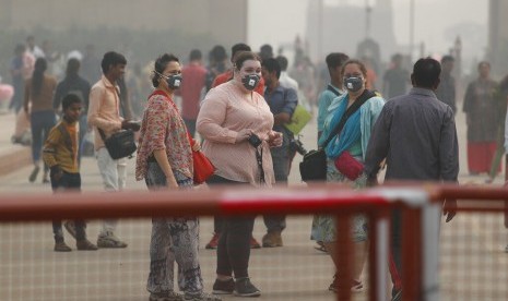 Warga India dan turis mengenakan masker untuk menghalau polusi udara saat berjalan di New Delhi, India, Senin (4/11). Menteri Lingkungan India menagih janji pembiayaan negara maju atasi perubahan iklim. Ilustrasi.