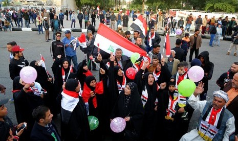 Warga Irak merayakan kemenangan militer yang berhasil mengalahkan ISIS di Tahrir Square, Baghdad, Irak, Ahad (10/12).