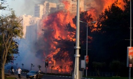 Warga Israel menyelamatkan diri dari kebakaran lahan.