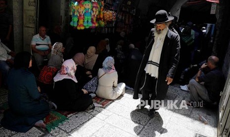 Warga Israel Ortodok melintasi warga Palestina di Kota Tua Yerusalem, Jumat (21/7)