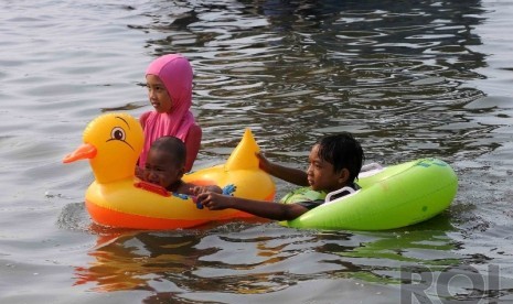 Warga Jakarta dan sekitarnya mengisi liburan dengan berenang di Pantai Festival Taman Impian Jaya Ancol (TIJA), Jakarta, Kamis (25/12). (Republika/Agung Supriyanto)