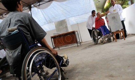  Warga Jakarta penyandang disabilitas tuna daksa dengan bantuan petugas menggunakan hak suaranya dalam Pilkada DKI Jakarta putaran kedua.  (Aditya Pradana Putra/Republika)