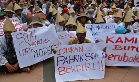 Warga Kabupaten Rembang pendukung pembangunan pabrik semen membentangkan poster saat berunjuk rasa di Semarang, Jawa Tengah, Selasa (13/12). 