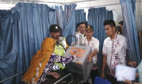 Warga Kabupaten Tasikmalaya yang sakit di RSUD Singaparna Medika Citrautama (SMC) melakukan pencoblosan dengan dibantu Panitia Pemungutan Suara (PPS) di TPS 09, Cikunten, Singaparna Kabupaten Tasikmalaya, Rabu (9/12). (Republika/Fuji EP) 