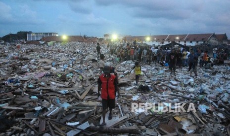 Warga Kampung Luar Batang korban penggusuran melintas diantara reruntuhan di Penjaringan, Jakarta Utara, Selasa (19/4). (Republika/Agung Supriyanto)