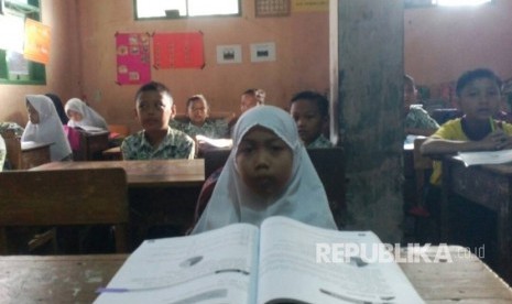 Warga Kampung Nagarakasih Kaler, Kelurahan Kersanegara, Kecamata Cibeureum, Kota Tasikmalaya, Melly  Faridatul Fuadah tetap semangat sekolah meski mengalami kelumpuhan, Kamis (18/5). Ia kesekolah dengan digendong ayahnya.