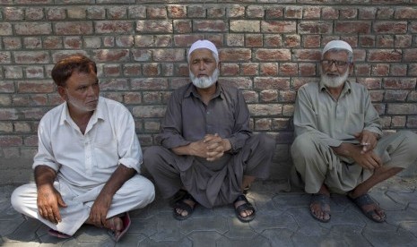 Warga Kashmir di luar kantor polisi menunggu kabar keluarga mereka yang ditahan saat penggerebekan polisi di Srinagar, Kashmir yang dikuasai India, Selasa (20/8).