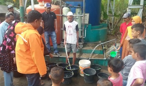 Warga Kelurahan SIngkup, Kecamatan Purbaratu, mengantre air di depan instalasi pengolahan air, Kamis (11/7).