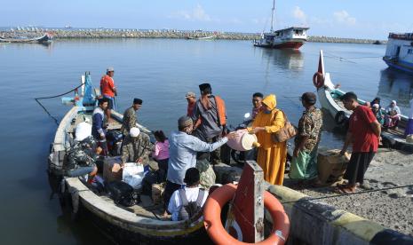 Warga kepulauan bersiap naik ke perahu untuk mudik lebih awal di Pelabuhan Kalbut, Situbondo, Jawa Timur, Sabtu (16/4/2022). Warga Pulau Sapudi Sumenep mudik lebih awal menggunakan perahu motor meskipun perlengkapan keselamatan penumpang yang dimiliki perahu tersebut terbatas karena tidak ada sekoci dan pelampung keselamatan. 