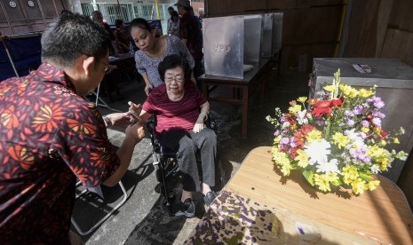 Warga keturunan Tionghoa mencelupkan jari ke dalam tinta usai memberikan hak suara dalam Pilkada DKI Jakarta di TPS 4 Glodok, Tamansari, Jakarta Barat, Rabu (15/2). 