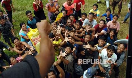 Earthquake victims in Sirenja, Palu, Central Sulawesi, receive assistance dropped from a helicopter, Sunday (October 7).