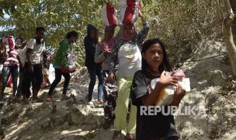 Warga korban gempa dan tsunami membawa bantuan dari Persiden Joko Widodo di Desa Loli Saluran, Donggala, Sulawesi Tengah, Rabu (3/10). 