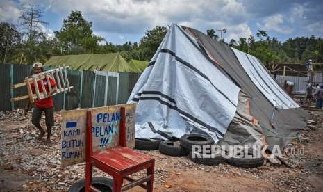 Warga korban gempa membangun hunian sementara yang terbuat dari sisa-sisa bahan bangunan dan terpal di Desa Dopang, Gunungsari, Lombok Barat, NTB, Ahad (23/9). 