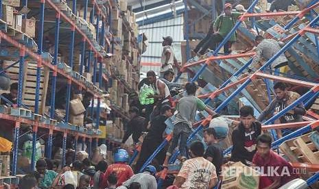 Warga korban gempa mengambil berbagai keperluan logistik di Mamboro, Palu Utara, Sulawesi Tengah, Senin (1/10). Warga di wilayah Palu Utara hingga Donggala bagian pantai Barat terpaksa mengambil berbagai kebutuhan tersebut karena bantuan belum sampai ke lokasi. 