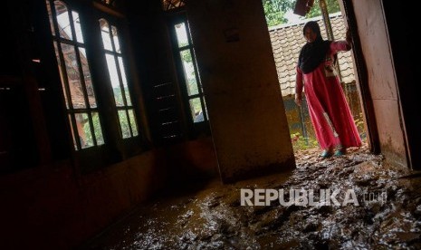 Warga korban longsor dan banjir bandang mengamati rumahnya yang terkena longsor di Kampung Gunung Julang, Desa Lebaksitu, Kecamatan Lebak Gedong, Banten, Senin (13/1). Daerah yang terkena longsor di Desa Lebaksitu sebanyak tiga Rukun Tetangga dengan total kerusakan 13 rumah rusak dan 5 rumah rata dengan tanah.