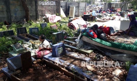 Warga korban penggusuran Kampung Palem Nuri, Kelurahan Panunggangan Barat, Kota Tangerang memilih bertahan dan tidur di atas pemakaman umum yang bersebelahan dengan lokasi penggusuran, Kamis (7/12).