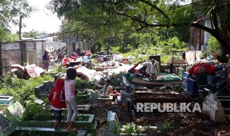 Warga korban penggusuran Kampung Palem Nuri, Kelurahan Panunggangan Barat, Kota Tangerang memilih bertahan dan tidur di atas pemakaman umum yang bersebelahan dengan lokasi penggusuran, Kamis (7/12).