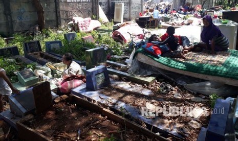 Warga korban penggusuran Kampung Palem Nuri, Kelurahan Panunggangan Barat, Kota Tangerang memilih bertahan dan tidur di atas pemakaman umum yang bersebelahan dengan lokasi penggusuran, Kamis (7/12).