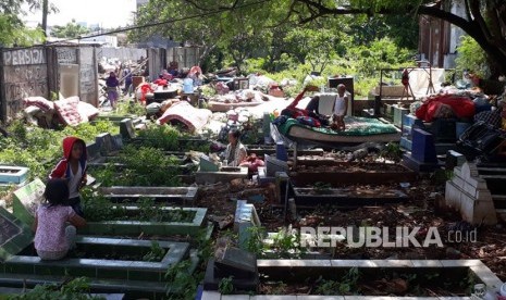 Warga korban penggusuran Kampung Palem Nuri, Kelurahan Panunggangan Barat, Kota Tangerang memilih bertahan dan tidur di atas pemakaman umum yang bersebelahan dengan lokasi penggusuran, Kamis (7/12).