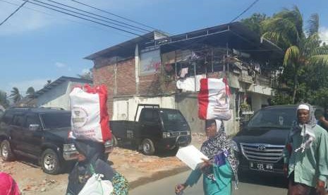 Warga korban terdampak gempa mengambil bantuan sembako dari Presiden Joko Widodo (Jokowi) di Pemenang, Kabupaten Lombok Utara, NTB, Ahad (2/9).