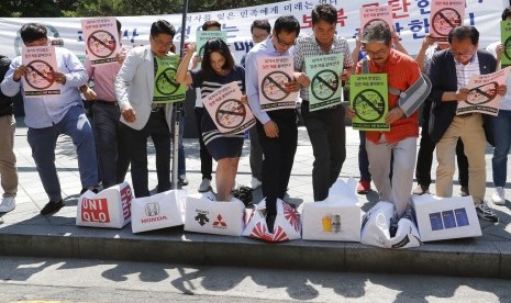 Warga Korea Selatan (Korsel) menginjak kardus yang menyimbolkan produk Jepang di depan Kedubes Jepang di Seoul, Korsel, Jumat (5/7). Warga Korsel protes keputusan Jepang membatasi ekspor.