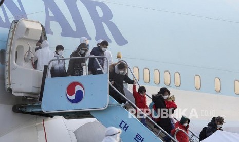 Warga Korea Selatan yang dievakuasi dari Kota Wuhan turun dari pesawat setelah mendarat di  Gimpo International Airport, Gimpo, Korea Selatan, Jumat (31/1).