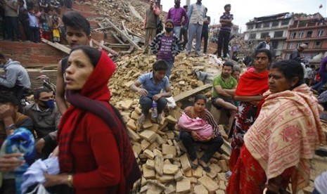  Warga kota Kathmandu duduk diatas reruntuhan bangunan yang hancur akibat gempa, Sabtu (25/4).