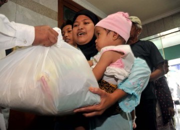 Warga kurang mampu atau dhu'afa mendapat bantuan sembako dalam Bazar Amal di Masjid Agung Sunda Kelapa, Jakarta Pusat, Ahad (17/7). Pembagian sembako ini diadakan oleh majelis ta'lim Masjid Agung Sunda Kelapa dalam rangka menyambut Bulan Suci Ramadhan 1432