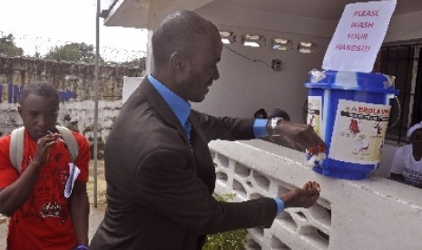 Warga Liberia tengah mengantri untuk mencuci tangan. Sesuai anjuran WHO, kebersihan menjadi prioritas penting guna mencegah penyebaran Ebola.