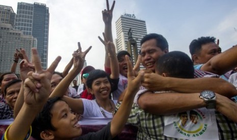 Warga masyarakat menyambut hasil quick count yang mengunggulkan pasangan capres-cawapres Joko Widodo - Jusuf Kalla dengan melakukan perayaan di kawasan Bundaran Hotel Indonesia, Jakarta, Rabu (9/7). 