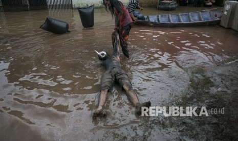 Warga melakukan aksi teatrikal di area banjir pada acara Pentas Bandung Lautan Banjir di Bojongasih, Dayeuhkolot, Kabupaten Bandung, Jawa Barat, Ahad (14//4/2019).