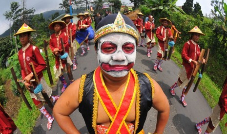 Warga melakukan arak-arakan dengan memainkan musik 