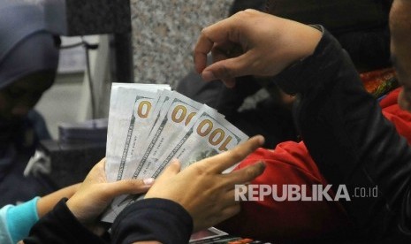  Warga melakukan penukaran mata uang asing di tempat penukaran uang (money changer) di Jakarta, Rabu (11/1).