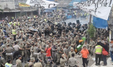 Warga melakukan perlawanan saat Satpol PP melakukan penggusuran pemukiman liar di Kampung Pulo, Jatinegara, Jakarta, Kamis (20/8).   (Republika/Yasin Habibi)