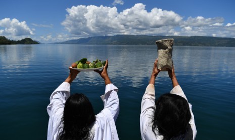 Warga melakukan ritual doa di dermaga Tigaras, Danau Toba, Simalungun, Sumatera Utara, Sabtu (30/6).