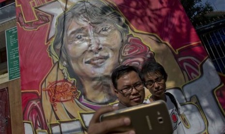 Warga melakukan swafoto dengan latar belakang pemimpin oposisi Myanmar Aung San Suu Kyi di Yangon, Myanmar, Jumat, 13 November 2015. Partai Suu Kyi menang telak dalam pemilu. 