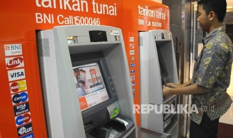  Warga melakukan transaksi menggunakan mesin ATM Bank BNI.