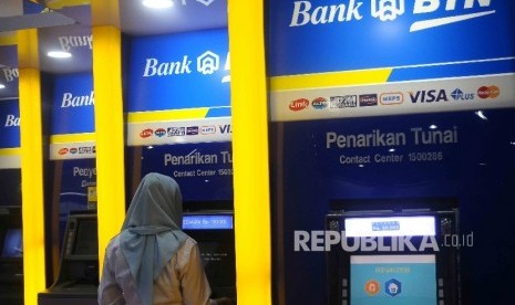 Warga melakukan transaksi menggunakan mesin ATM Bank BTN di Jakarta, Ahad (31/7). (Republika/ Agung Supriyanto)