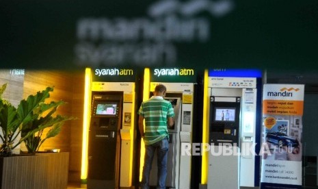  Warga melakukan transaksi menggunakan mesin ATM Bank Syariah Mandiri (BSM) di Jakarta, Ahad (4/12).